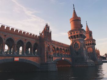 Bridge over river in city against sky