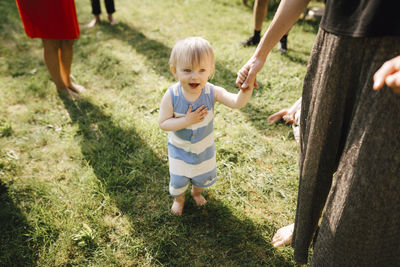 Toddler boy holding mother's hand