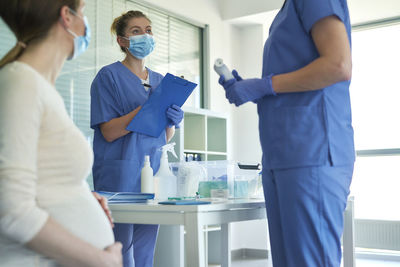 Female doctors discussing by patient in hospital