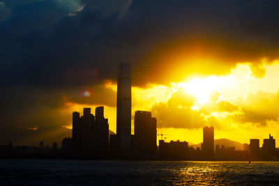 Buildings in city against sky during sunset