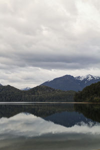 Scenic view of lake by mountains against sky