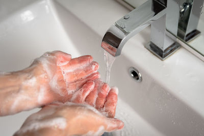 Close-up of human hand in bathroom