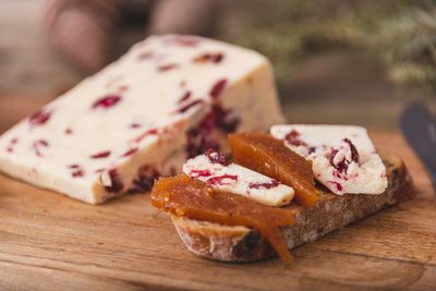 An assortment of various types of cheese with wine, and grapes, shot from above on a dark rustic 