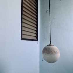 Low angle view of electric lamp hanging on wall