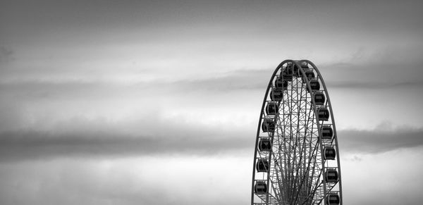 Ferris wheel by sea against sky