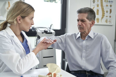 Portrait of doctor examining patient in office