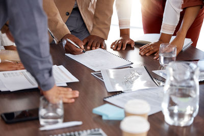 Midsection of business colleagues working on table