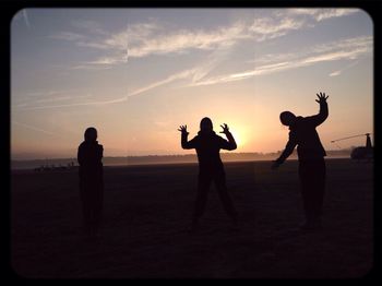 Silhouette of woman jumping at sunset