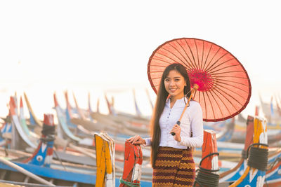 Woman smiling at beach against sky