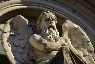 Low angle view of angel statue against historic building