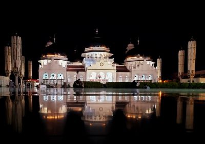 Reflection of illuminated buildings in lake at night