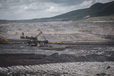 View of open-pit mine against cloudy sky