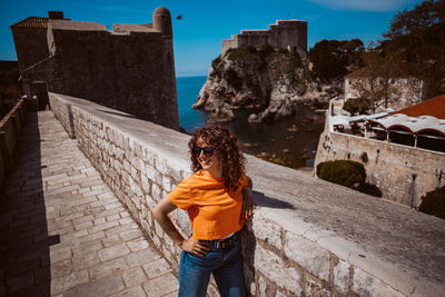 Rear view of woman standing against building