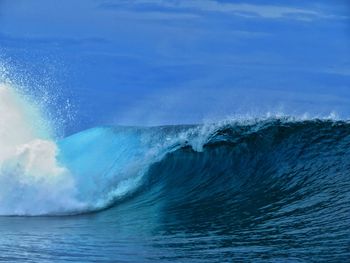 Sea waves splashing against blue sky