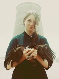 Portrait of woman holding bird