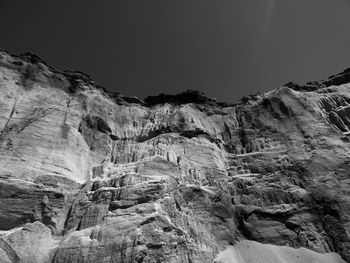 Low angle view of rocky mountains against clear sky