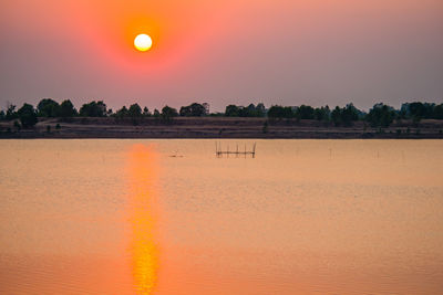 Scenic view of lake against orange sky