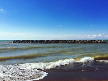 Scenic view of beach against clear blue sky