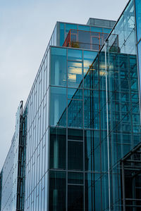 Low angle view of glass building against sky