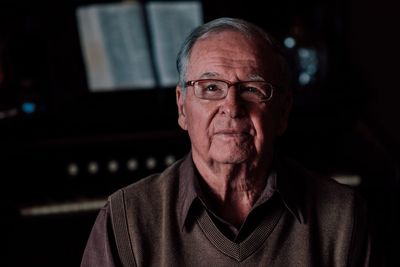 Portrait of senior man wearing eyeglasses in darkroom