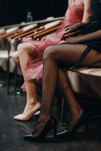 Female slender legs in elegant mesh tights and black high heel shoes