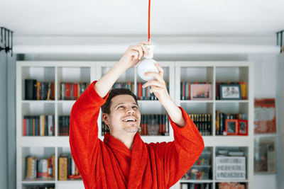 Midsection of man fixing lamp at home