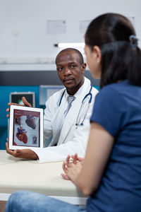 Side view of doctor examining patient in office