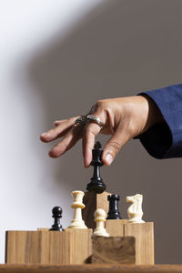 Cropped hand of man playing chess