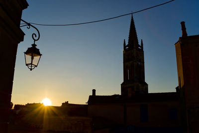 Hanging light against sky at sunset