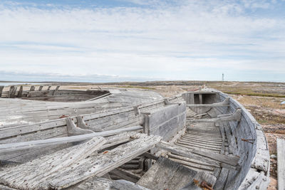 Abandoned wood on landscape against sky