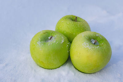 Freezing green apples on very cold snow