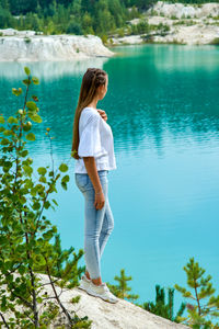 Rear view of woman standing by lake