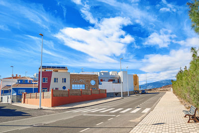 Buildings on coast with road nearby. mountains on horizon background. blue sky
