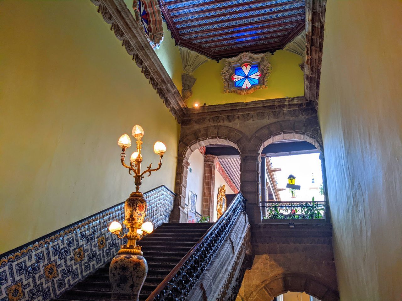 LOW ANGLE VIEW OF ILLUMINATED CHANDELIER HANGING ON BUILDING