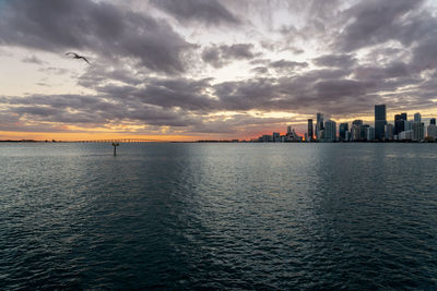 View of sea and buildings against sky during sunset