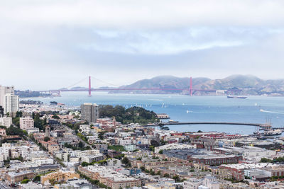 High angle view of city by sea against sky