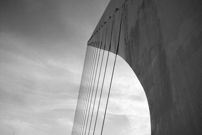 Low angle view of bridge against cloudy sky