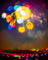 Low angle view of illuminated lights against sky at night