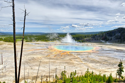 Scenic view of hot spring against cloudy sky