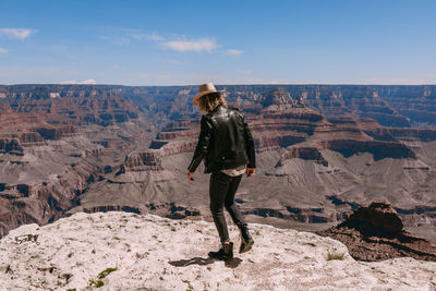 Full length of man standing on rock against sky