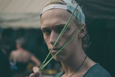 Close-up of young man holding grass