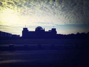 Built structures against sky at sunset