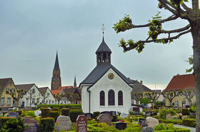 View of cemetery and buildings against sky