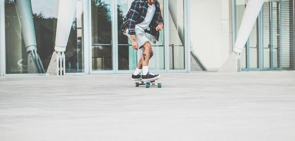 Low section of man skateboarding on footpath