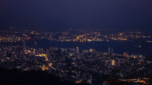 High angle view of illuminated city against sky at night