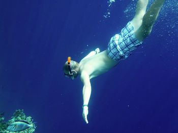 High angle view of shirtless man snorkeling in sea