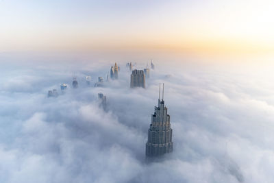 Aerial view of buildings against cloudy sky