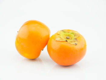 Close-up of orange fruit against white background