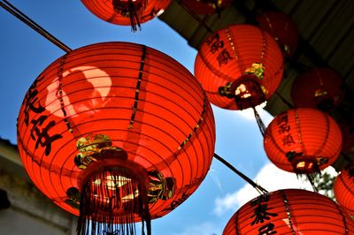 Low angle view of illuminated lanterns against sky at night