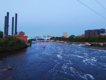 Bridge over river against buildings in city